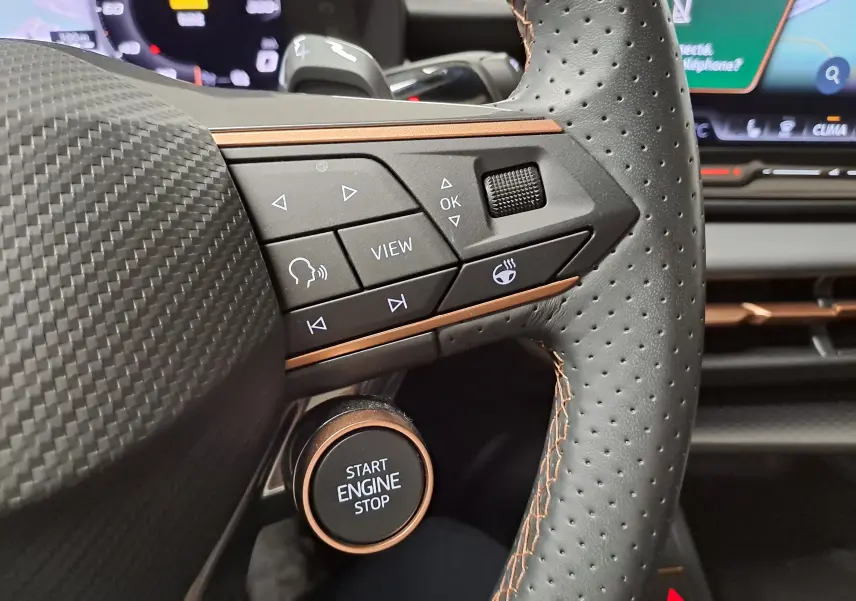 Gros plan sur la partie gauche du volant perforé du Cupra Terramar 2025 avec boutons multifonctions et bouton start/stop.