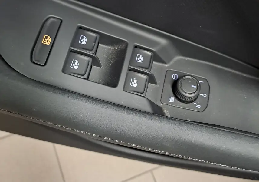 Gros plan sur les commandes de lève-vitres et réglage des rétroviseurs côté conducteur du CUPRA TERRAMAR noir Minuit.