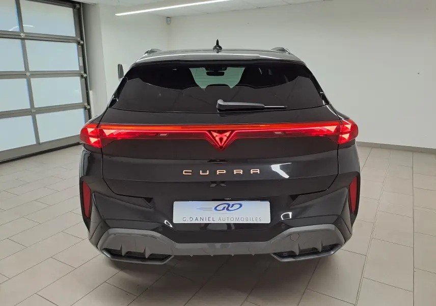 Vue arrière d'une CUPRA TERRAMAR 2025 en noir minuit avec feux LED continus et logo lumineux distinctif.