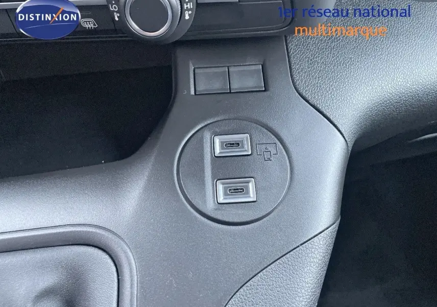 Vue rapprochée du tableau de bord noir du Peugeot Partner 2025, montrant deux ports USB-C intégrés.