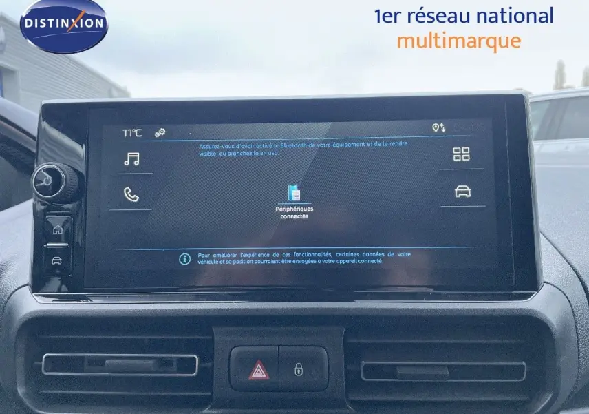 Vue intérieure centrée sur l'écran tactile du tableau de bord du Peugeot Partner 2025, affichant les périphériques connectés.