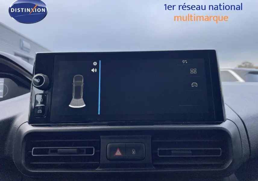 Écran tactile central du tableau de bord du Peugeot Partner 2025, affichant l'aide au stationnement, avec aérateurs noirs.