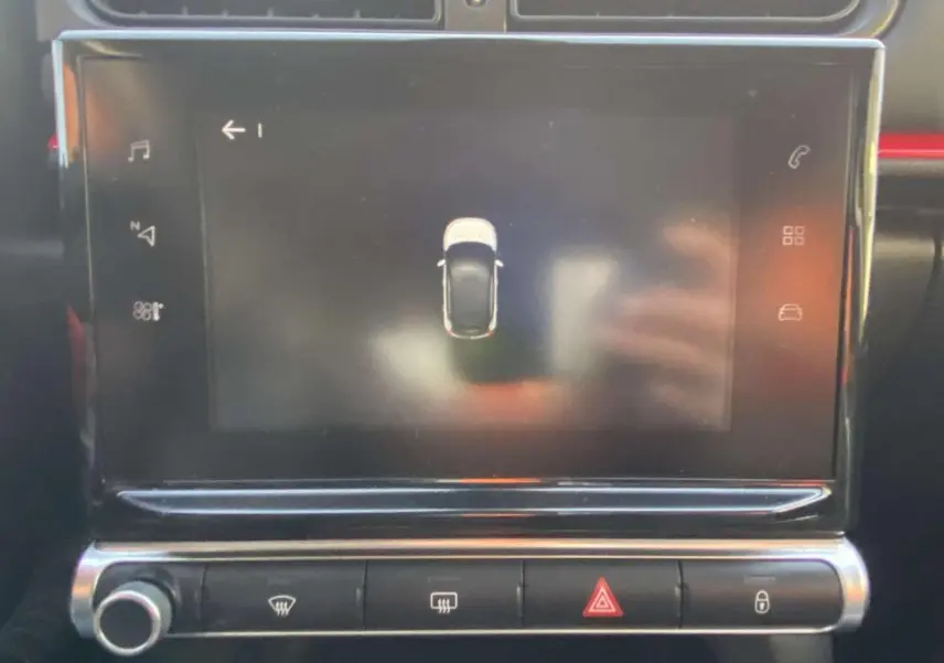 Écran tactile central de la Citroën C3 2017 affichant l'aide au stationnement avec vue du dessus du véhicule noir toit rouge.