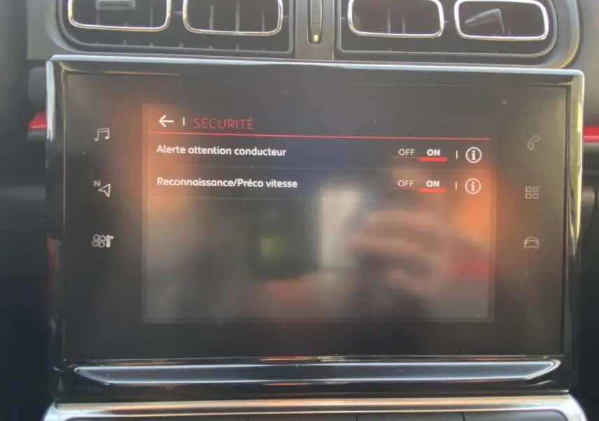 Gros plan sur l'écran tactile central du Citroën C3 noir toit rouge, affichant les réglages de sécurité du conducteur.