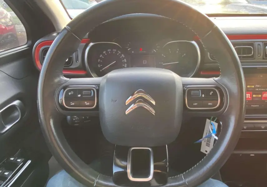 Vue rapprochée du volant noir de la Citroën C3 2017 avec tableau de bord et touches de commande intégrées.