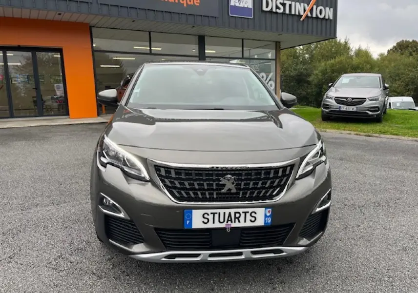 Vue de face d'un Peugeot 3008 gris amazonite métallisé, avec calandre noire et plaques d'immatriculation personnalisées.