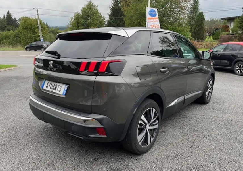 Peugeot 3008 gris amazonite vue 3/4 arrière droit, avec jantes alliage et feux arrière à griffes rouges.