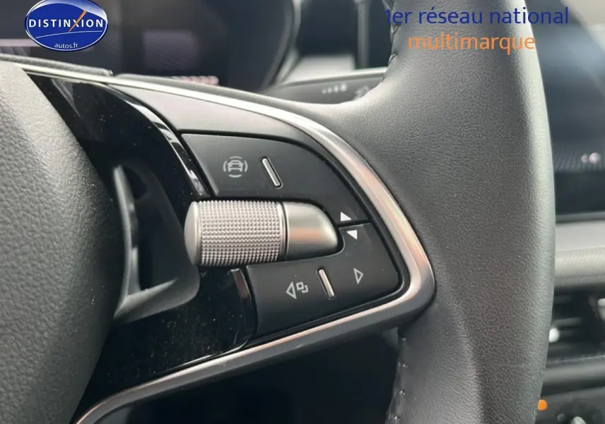 Gros plan sur les commandes multifonctions en métal et cuir du volant d’une Skoda Fabia blanche, version 2025.