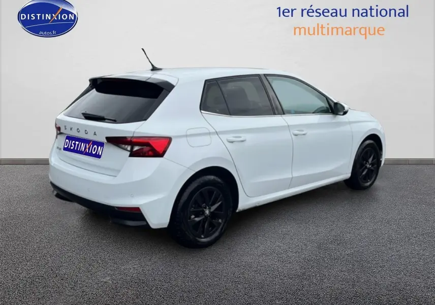 Vue 3/4 arrière droite d'une Skoda Fabia blanche 2025 avec jantes noires et vitres arrière teintées.