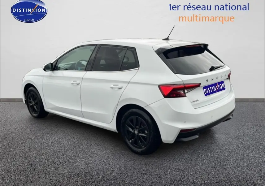 Vue 3/4 arrière droite d'une Skoda Fabia blanche avec jantes noires et feux arrière LED visibles.