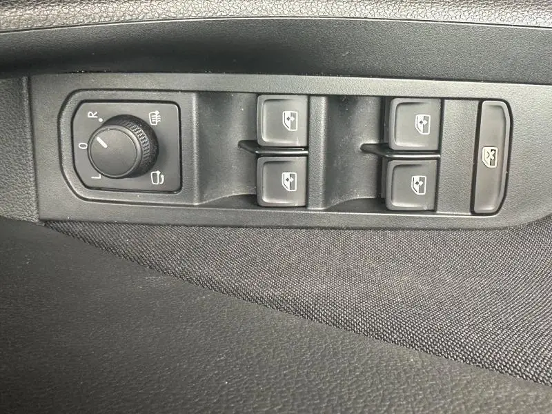 Vue rapprochée des commandes de lève-vitres et réglage des rétroviseurs côté gauche intérieur d'une Skoda Scala blanc cristal.