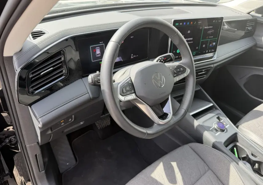 Vue intérieure côté conducteur du Volkswagen Tiguan 2025, volant cuir multifonction et écran tactile digital pro.