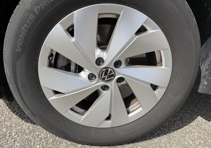 Gros plan sur la roue avant droite du Volkswagen Tiguan noir, jante alliage léger 17 pouces avec logo VW central.