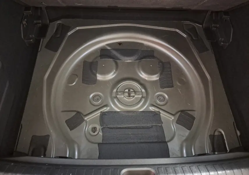 Vue plongeante sur le compartiment de roue de secours vide d'une CUPRA TERRAMAR 2025, gris Timanfaya.