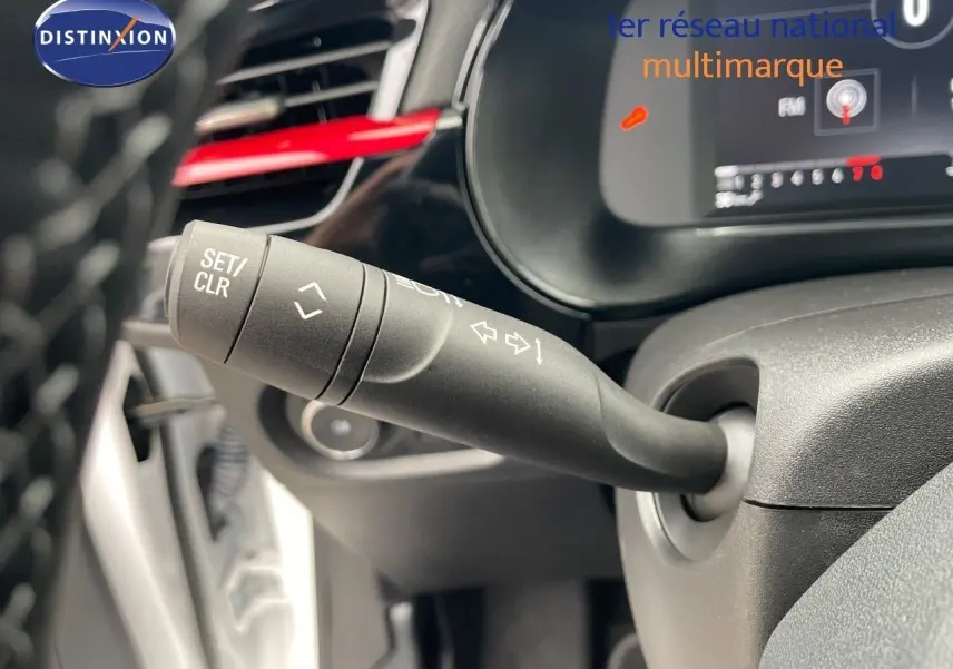 Gros plan sur la commande de clignotant à gauche du volant dans l'habitacle d'une Opel Corsa blanche 2022.