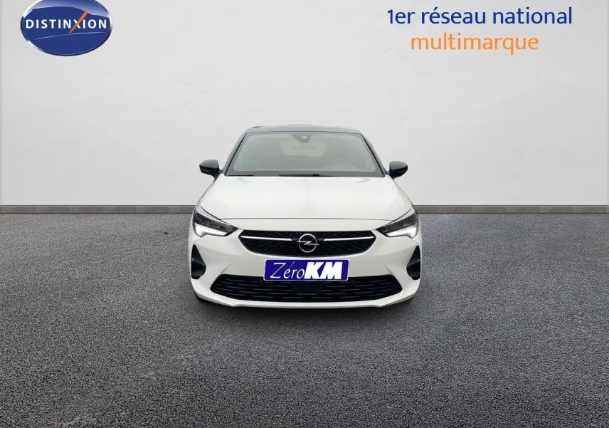 Vue frontale d'une Opel Corsa blanche 2022 avec calandre noire et phares LED allumés sur fond neutre.