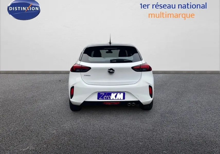 Vue arrière d'une Opel Corsa blanche 2022 avec double sortie d'échappement et feux arrière sombres sur fond neutre.