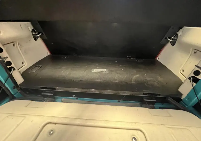 Vue rapprochée de la zone de coffre arrière du cabriolet Citroën E-MEHARI bleu clair de 2016, avec toit en toile replié.