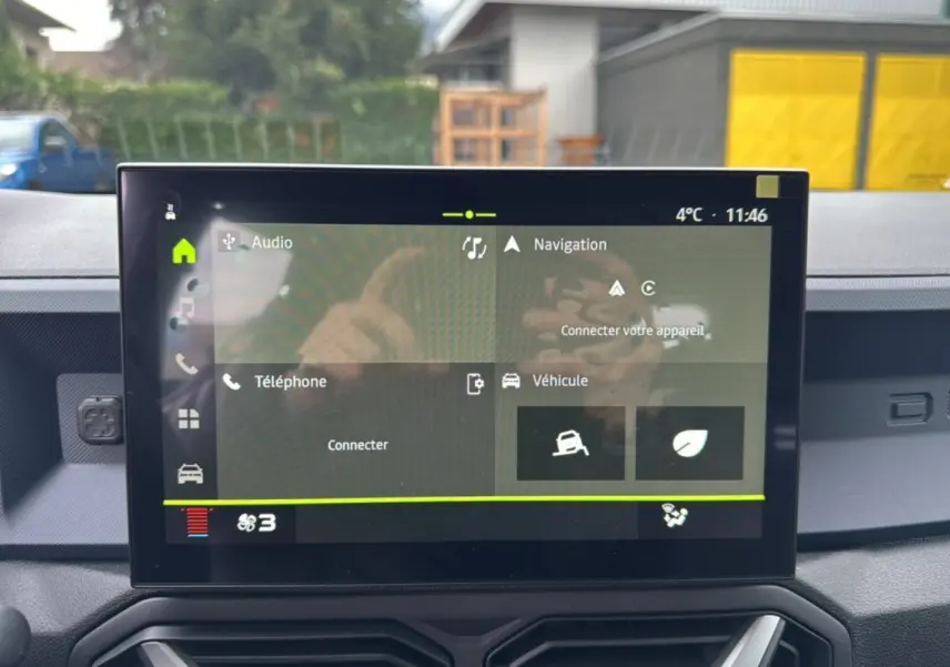 Écran tactile central du tableau de bord du Dacia Duster 2025 gris schiste, affichant les menus audio, navigation et véhicule.