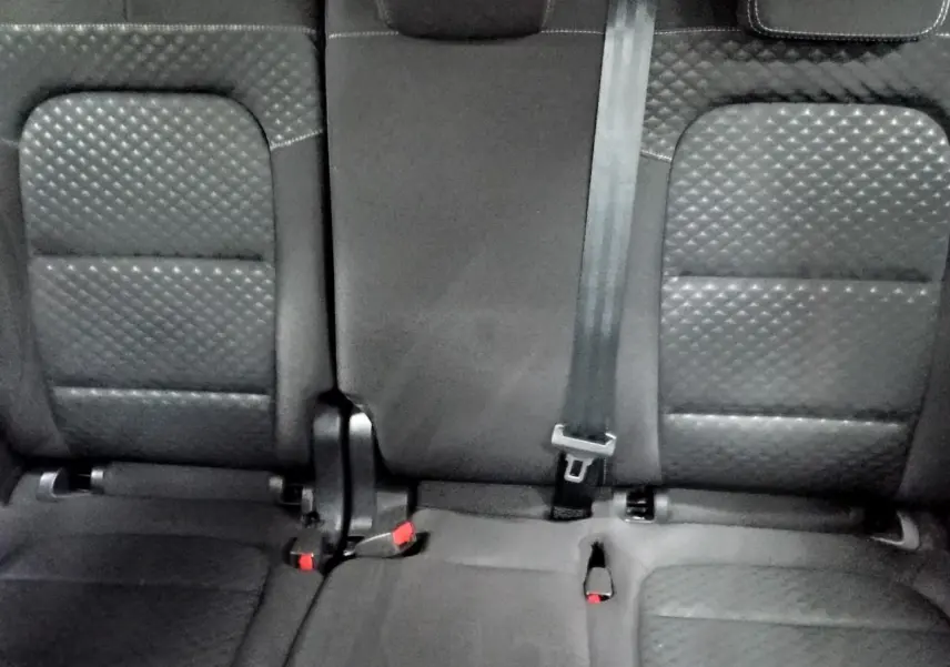 Vue rapprochée des sièges arrière noirs en tissu texturé du Ford Kuga 2024, avec ceinture de sécurité centrale visible.