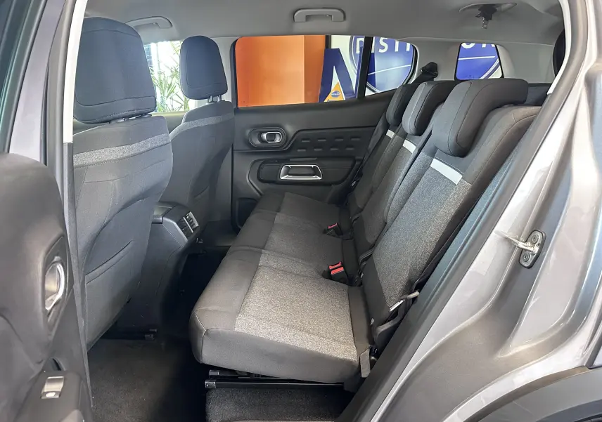 Vue latérale intérieure du Citroën C5 Aircross 2024 gris Artense, montrant la banquette arrière en tissu gris avec appuie-têtes.