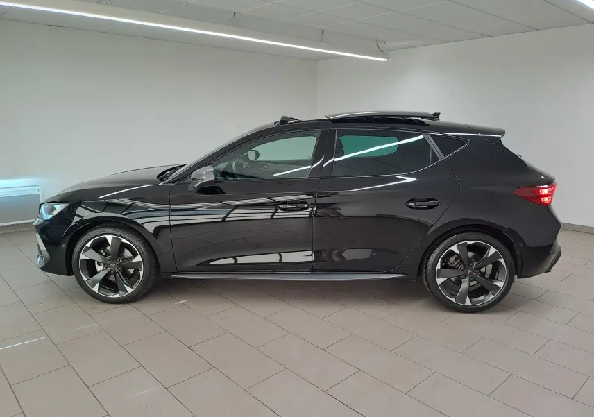 Vue de profil côté gauche d’une CUPRA Leon 2025 noire Minuit avec toit ouvrant panoramique et jupes latérales visibles.