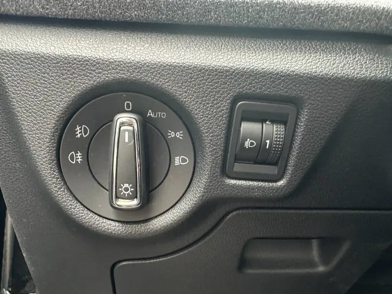 Gros plan sur la commande d’éclairage noire avec molette chromée dans l’habitacle d’une Skoda Scala noir Magic nacré.