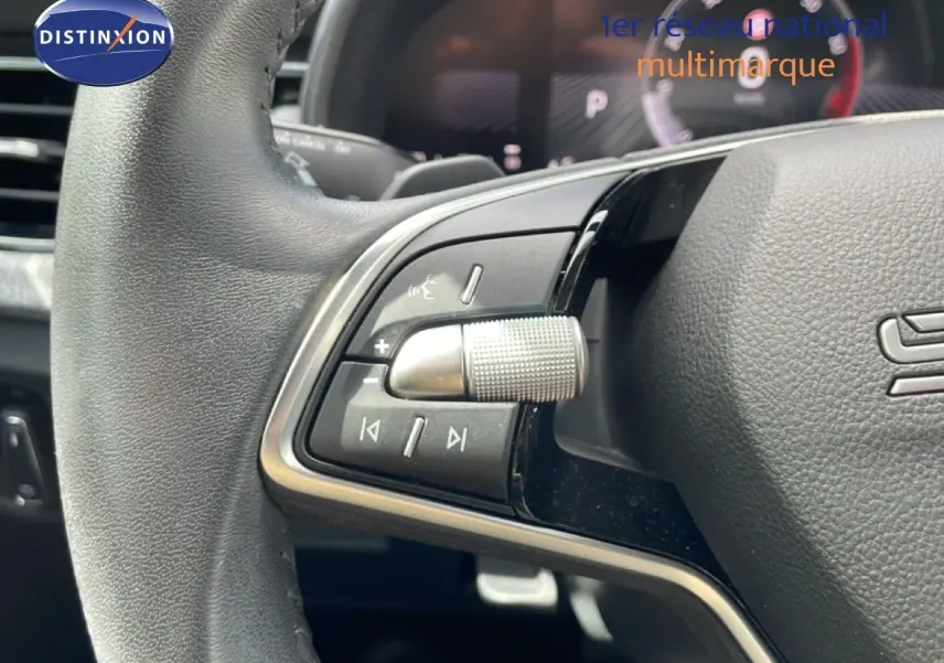 Gros plan sur le volant gris noir de la Skoda Scala 2025, avec commandes multimédia et molette texturée visible.