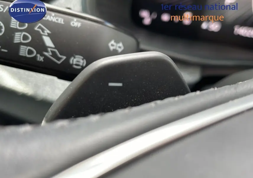 Gros plan sur la palette de changement de vitesse côté droit du volant d’une Skoda Scala blanche Glacier, intérieur noir.