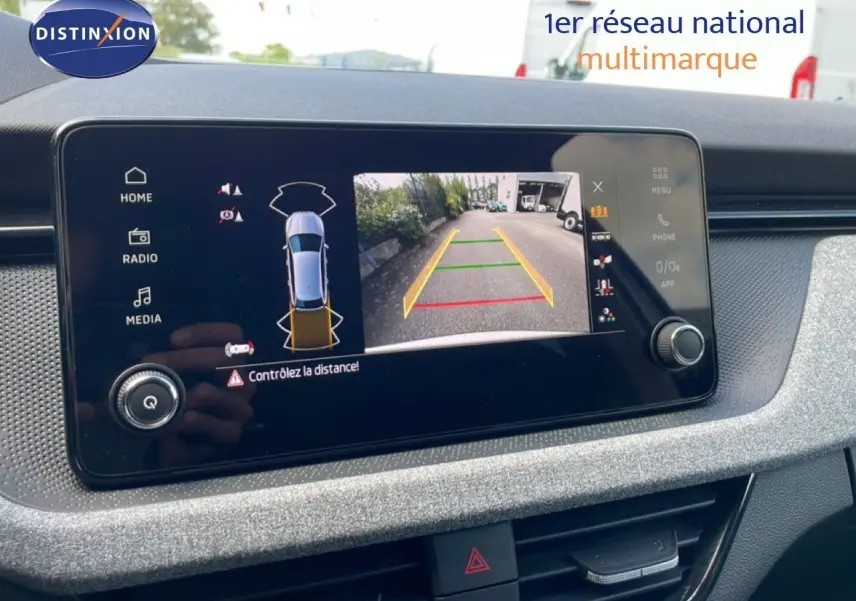 Écran central du Skoda Scala blanc glacier 2025 montrant la caméra de recul avec guidage dynamique.