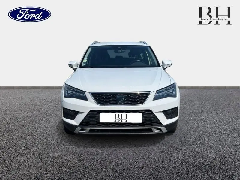 Vue avant d'un SEAT Ateca blanc Nevada Métal, mettant en valeur sa calandre noire et ses phares LED anguleux.