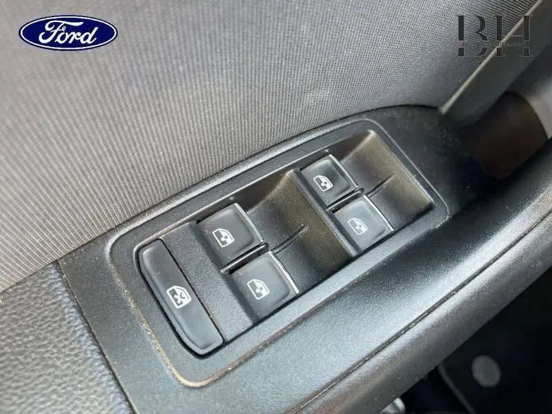 Gros plan sur les commandes des vitres électriques côté conducteur d'une SEAT Ateca blanc Nevada métal, version 2020.