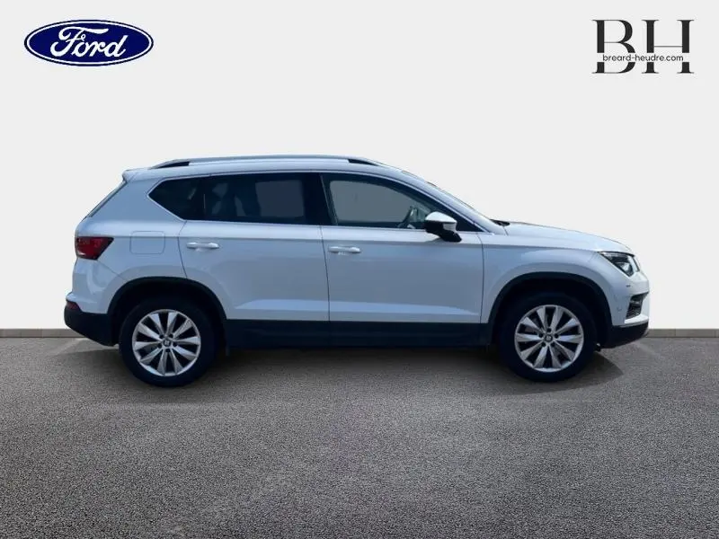 Vue latérale droite d'un SEAT Ateca blanc Nevada Métal avec jantes alliage et vitres arrière surteintées.