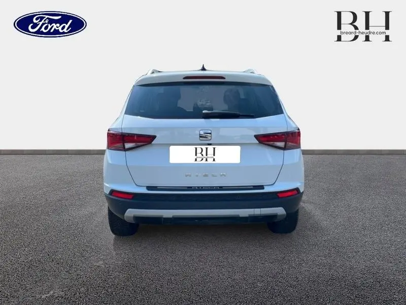 Vue arrière d'un SEAT Ateca blanc Nevada Métal 2020 avec feux arrière LED et hayon fermé sur fond neutre.