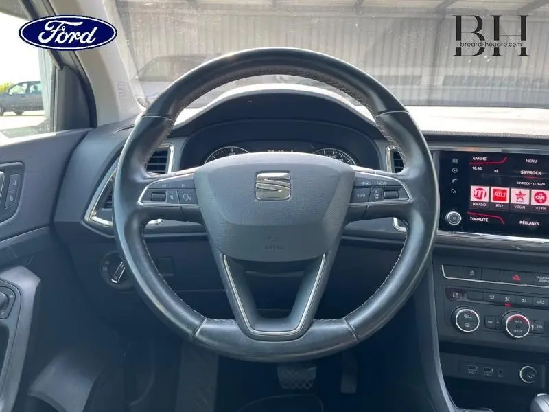 Vue intérieure centrée sur le volant cuir du SEAT Ateca blanc Nevada 2020 avec tableau de bord et écran tactile.