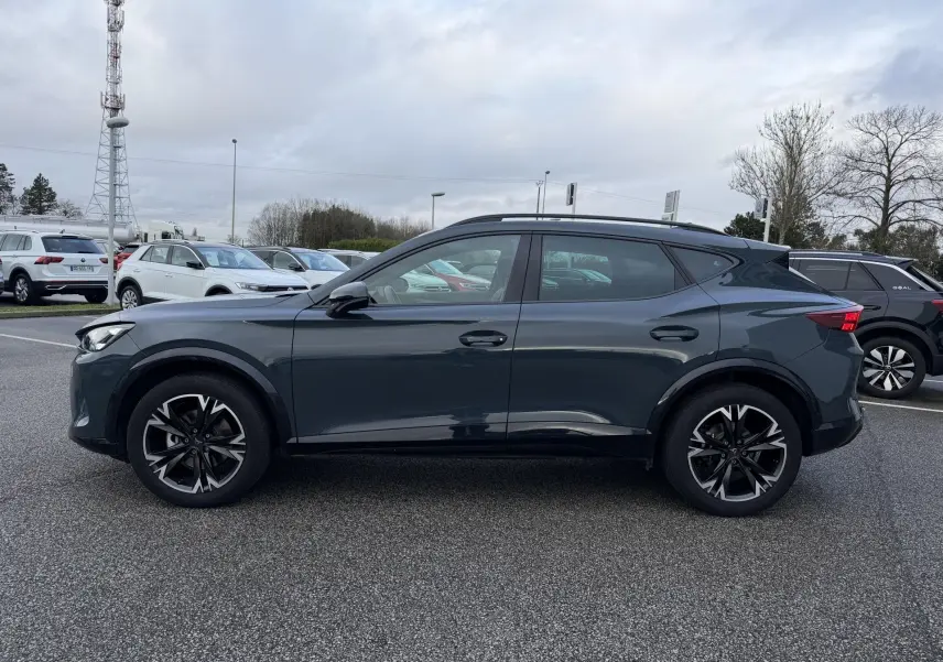 Vue de profil côté gauche d’un CUPRA Formentor bleu métallisé 2025, avec jantes noires et toit ouvrant.