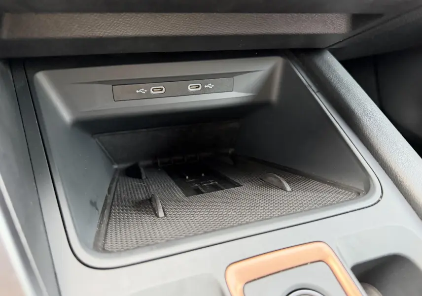 Gros plan sur la console centrale noire avec deux ports USB-C et un espace de rangement du CUPRA Formentor.