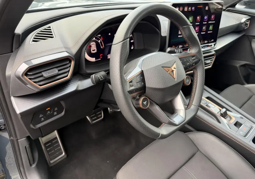 Vue intérieure côté conducteur du CUPRA Formentor 2025 avec volant cuir perforé, tableau de bord digital et écran tactile HD.