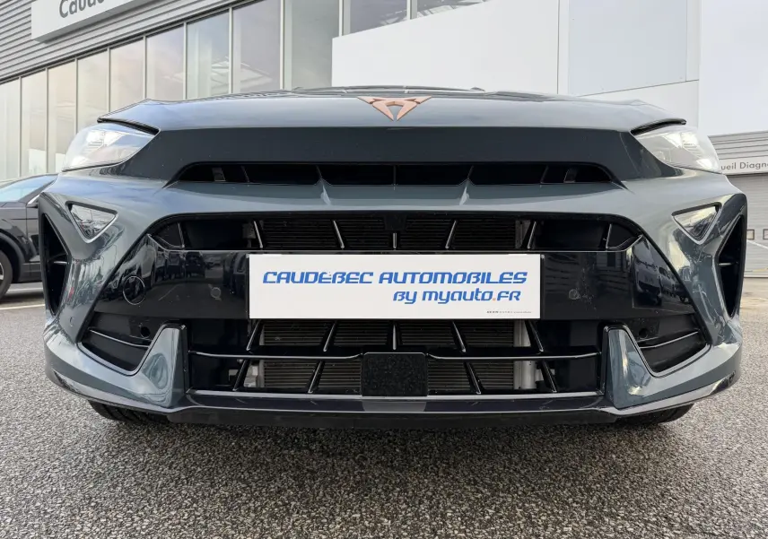 Vue frontale rapprochée de la CUPRA Formentor bleue avec logo cuivré et calandre large noire brillante.