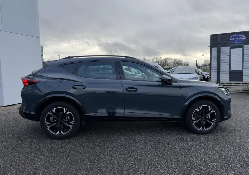 Vue latérale droite d'un CUPRA Formentor bleu métallisé 2025, soulignant ses jantes noires et son profil dynamique.