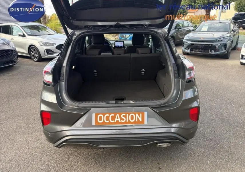 Vue arrière d'un Ford Puma gris foncé 2022 avec coffre ouvert, montrant l'espace de chargement vide.