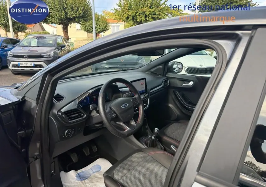 Vue intérieure côté conducteur du Ford Puma gris foncé 2022, avec volant, écran tactile et boîte manuelle visibles.