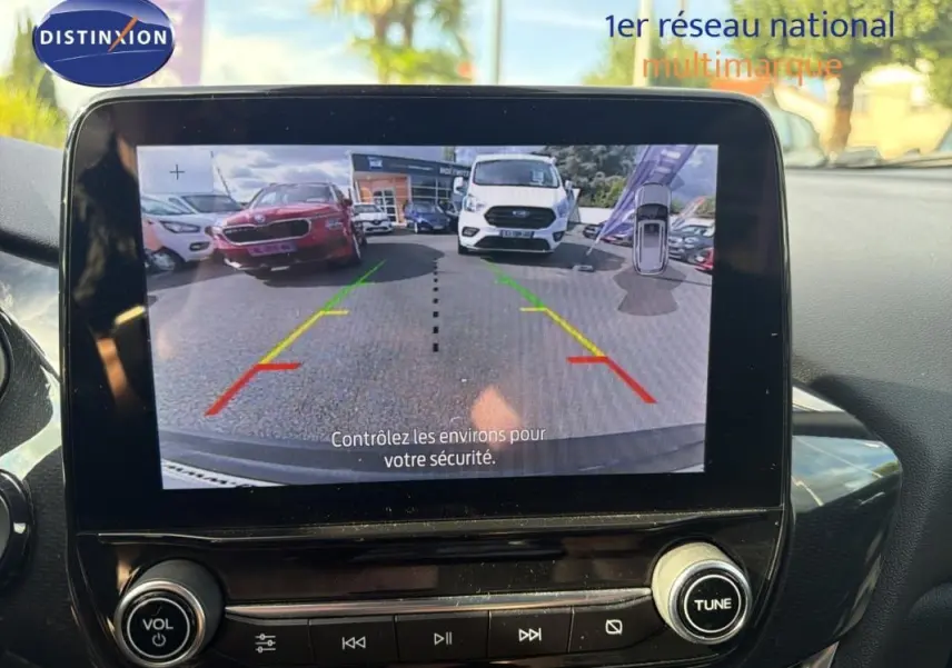 Écran tactile intérieur montrant la caméra de recul d’un Ford Puma gris foncé, vue arrière avec guidage de trajectoire.