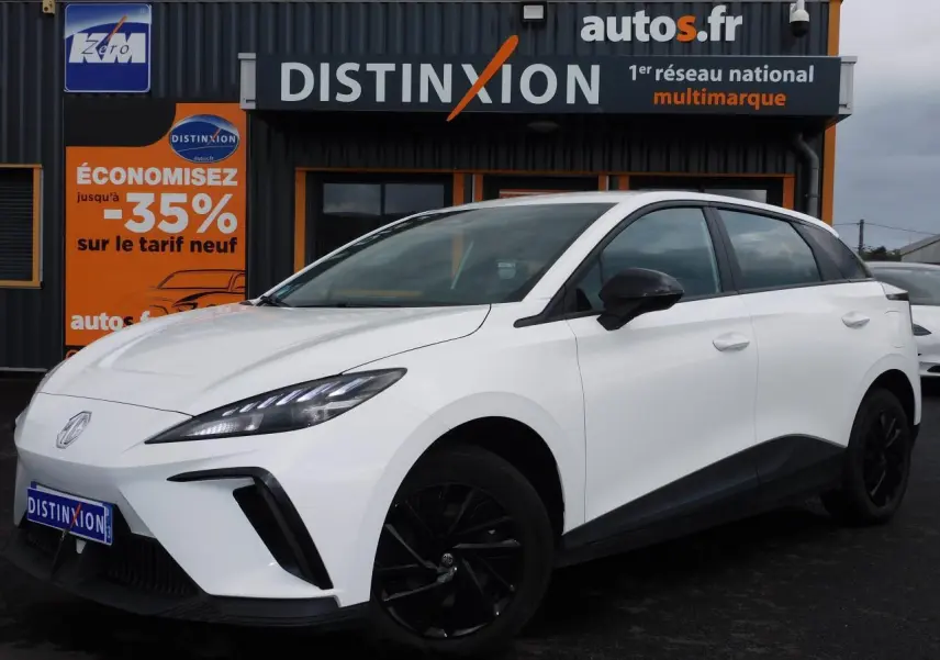 MG4 blanc en vue 3/4 avant droit, avec jantes noires et lignes épurées sous un ciel nuageux.