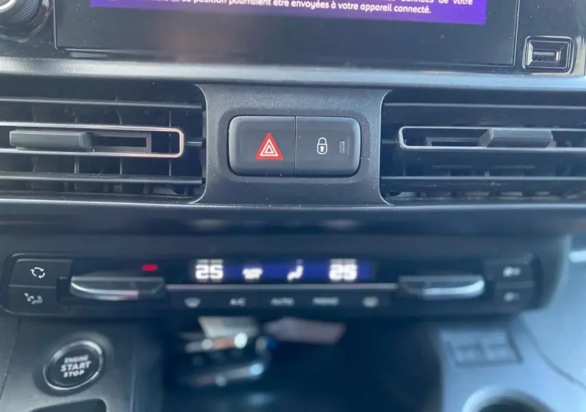 Détail du tableau de bord du Peugeot Rifter GT 2023 montrant la climatisation automatique bi-zone et les boutons de sécurité.