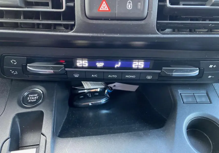 Tableau de bord du Peugeot Rifter GT 2023, vue rapprochée sur la climatisation bi-zone et bouton start/stop.