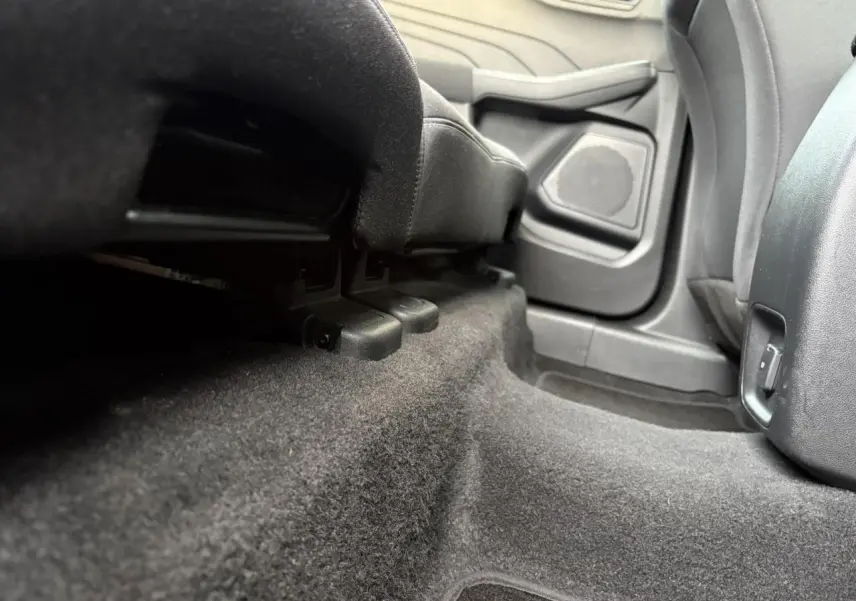 Vue rapprochée du plancher arrière côté droit du Ford Kuga 2024 gris Solar, montrant la moquette et la base des sièges.