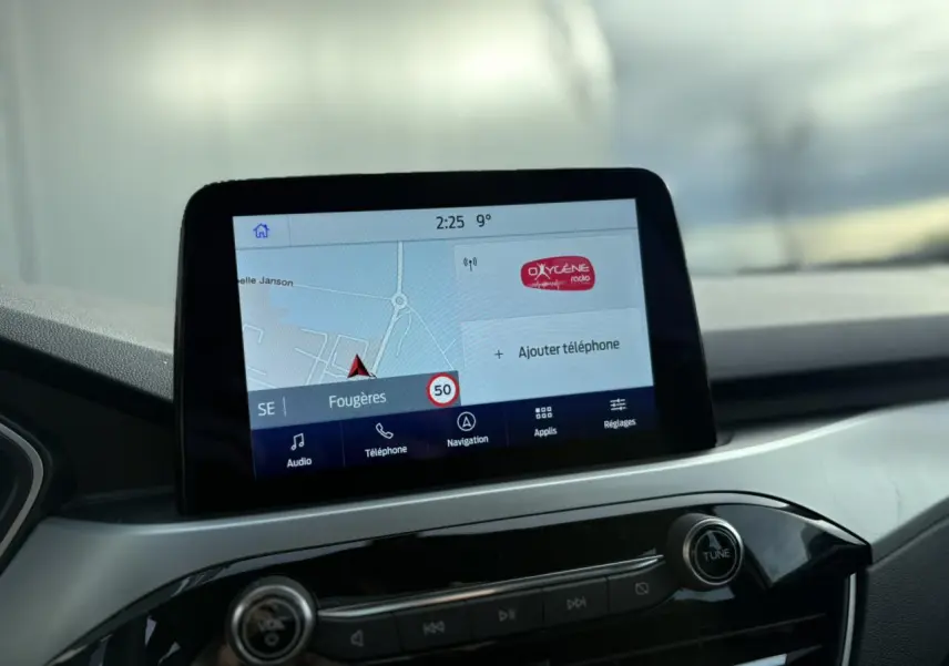 Écran tactile GPS en gros plan dans l’habitacle du Ford Kuga 2024, avec tableau de bord gris et commandes noires.
