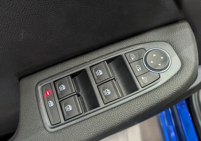 Commande des vitres électriques et réglage des rétroviseurs sur la porte côté conducteur d’une Renault Clio V Bleu Iron.