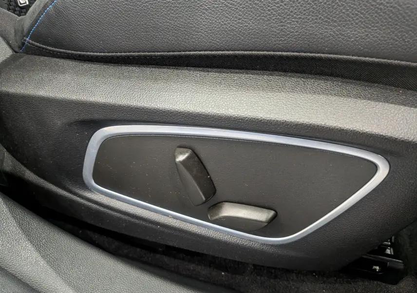 Gros plan sur les commandes de réglage électrique du siège avant noir du Renault Austral E-Tech hybrid 200 Iconic esprit Alpine.